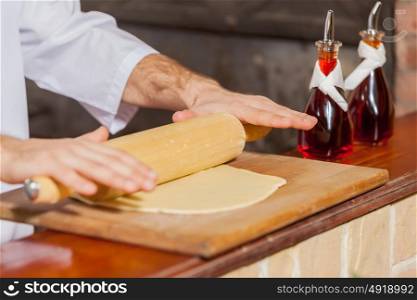 Close-up of cook hands. Close-up image of cook hands rolling out dough