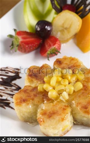 Close-up of corn cakes and fruits in a plate