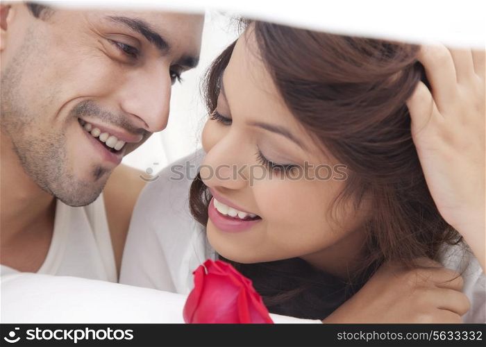 Close-up of couple romancing in bed