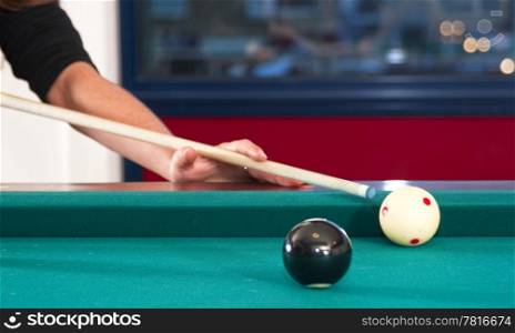 Close up of cue ball and cue stick during a game of pool