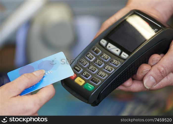 Close Up Of Customer In Shop Making Purchase Using Contactless Payment