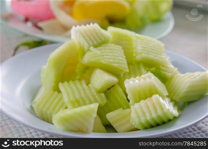 close up of cut green melon on the shallow dish. green melon
