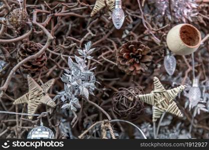 Close-up of Decorating Christmas tree background. Twigs christmas tree, brown natural pine cones, Disco ball, Star and edison light bulb, Selective focus.