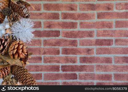 Close up of decorative Christmas cones at left side against of brick wall