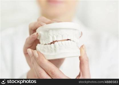 Close-up of dentist holding dentures at clinic