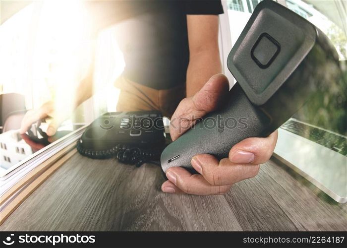 close up of designer hand holding telephone in the office as concept incoming call for you