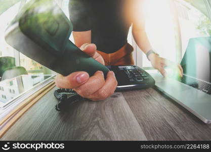 close up of designer hand holding telephone in the office as concept incoming call for you