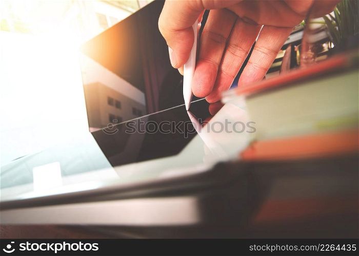 close up of Designer hand working with laptop computer on wooden desk as responsive web design concept
