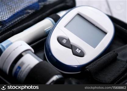 Close up of diabetic measurement tools in bag on table .. Close up of diabetic measurement tools in bag on table