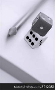Close-up of dices with a pencil
