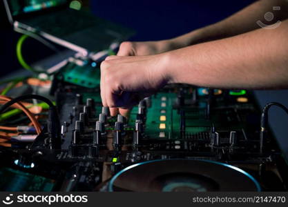 Close-Up of Dj Mixer Controller Desk in Night Club Disco Party. DJ Hands touching Buttons and Sliders Playing Electronic Music . High quality photography.. Close-Up of Dj Mixer Controller Desk in Night Club Disco Party. DJ Hands touching Buttons and Sliders Playing Electronic Music .
