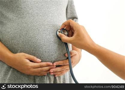 Close-up of Doctor checking pregnant woman with stethoscope.