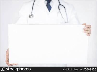 close up of doctor holding blank white banner