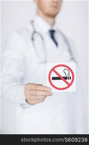 close up of doctor holding no smoking sign in hands