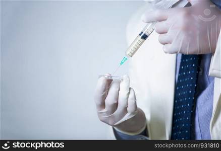Close-Up Of doctor holding Syringe Against White Background