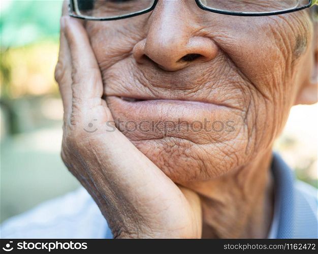Close up of Elderly man biting on cotton gauze after tooth extraction, Tooth decay from not like brushing teeth. Oral care concepts.