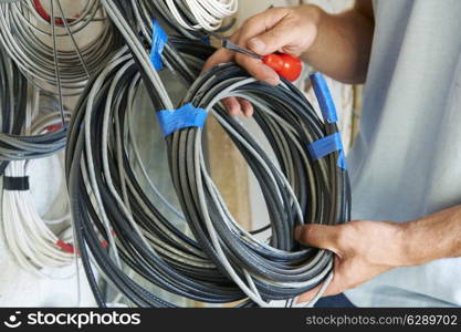 Close Up Of Electrician Fitting Wiring On Construction Site