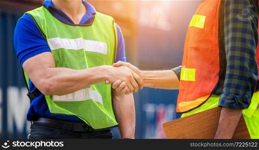 Close up of engineer and foreman worker handshake with blurred construction site, Success and Teamwork concept
