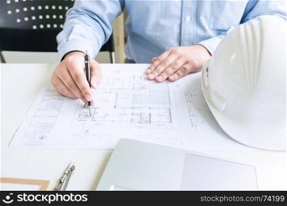 close up of engineer sketching on blueprint on desk in creative office