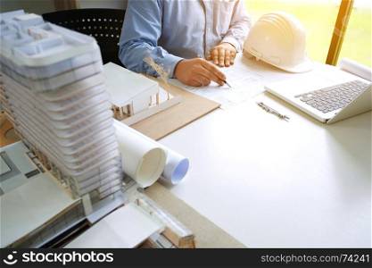 close up of engineer sketching on blueprint on desk in creative office