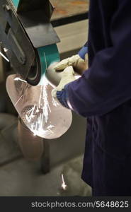 Close Up Of Engineer Using Grinding Machine In Factory