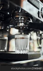 Close up of espresso pouring from coffee machine. Professional coffee brewing. Close up of espresso pouring from coffee machine.