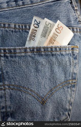Close-up of euro notes in the pocket of a pair of jeans