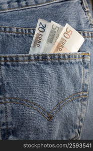 Close-up of euro notes in the pocket of a pair of jeans