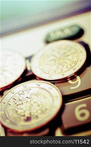 Close-up of European union coins on a calculator