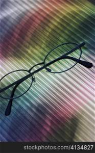 Close-up of eyeglasses on a multi-colored surface