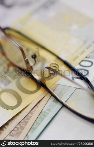 Close-up of eyeglasses on an one hundred Euro banknote