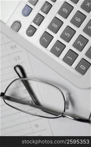 Close-up of eyeglasses with a calculator on a diary
