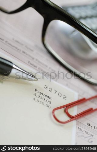 Close-up of eyeglasses with a pen and a document