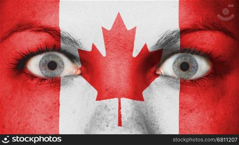 Close up of eyes. Painted face with flag of Canada