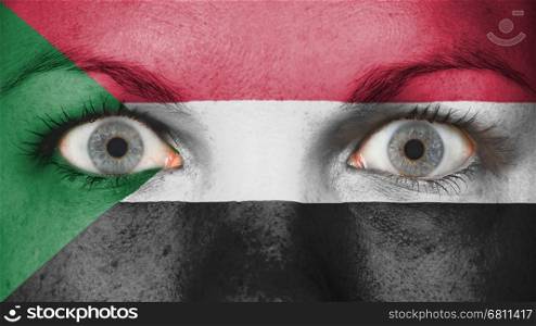 Close up of eyes. Painted face with flag of Sudan