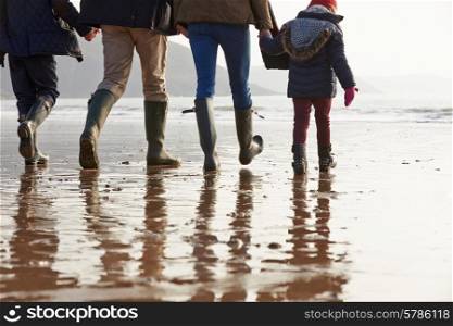 Close Up Of Family Walking Along Winter Beach