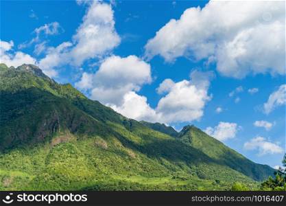 Close up of Fansipan mountain hills valley with forest trees at noon. Panoramic view at Sapa, Vietnam. Natural landscape background.