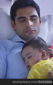 Close-up of father and baby sleeping