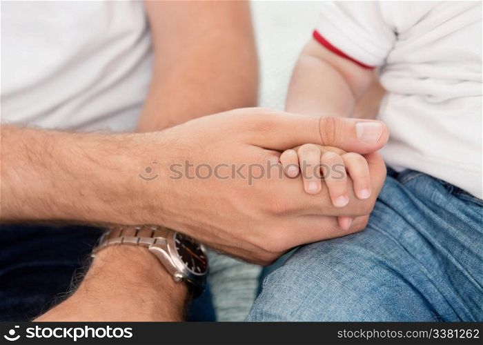 Close-up of father holding child&rsquo;s hand