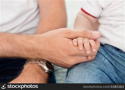 Close-up of father holding child&rsquo;s hand