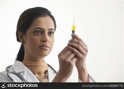 Close-up of female doctor holding syringe isolated over white background