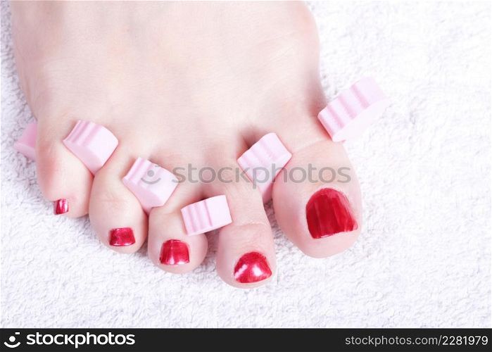 Close-up of female feet with red polished nails carefree, chiropody