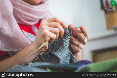 Close up of female fingers knitting at home