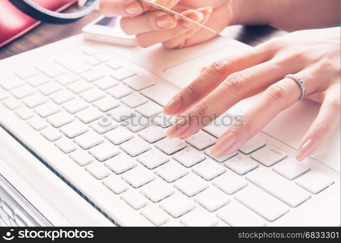 Close up of female fingers using laptop and credit card, Working woman and Online shopping concept, Selective focus