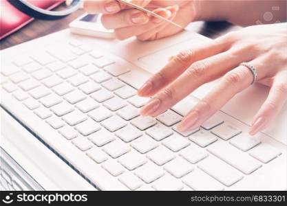 Close up of female fingers using laptop and credit card, Working woman and Online shopping concept, Selective focus