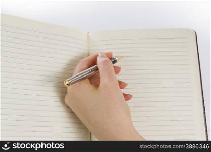 Close up of female hand with pen and paper ready to write on white background.