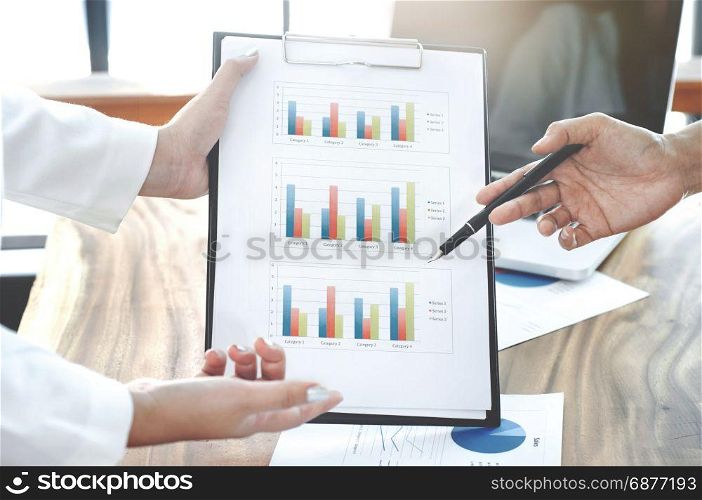 Close-up of female hands pointing at business document while discussing at meeting