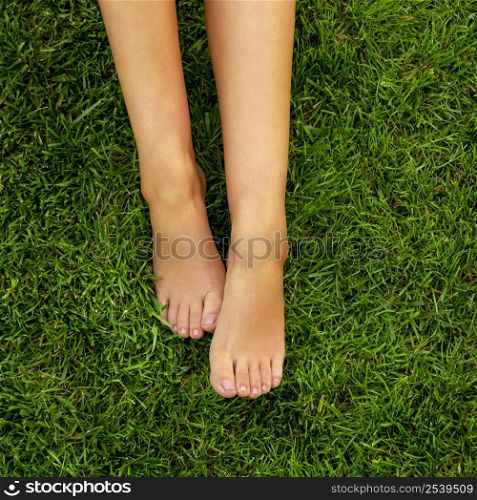 Close-up of female legs over the grass
