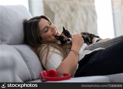 Close up of female owner holding her lovely black and white cat at home. Concept of love to animals, pets, care, tranquility.