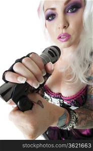 Close-up of female punk holding microphone over white background